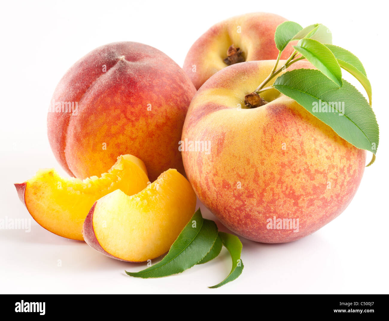 Reife Pfirsichfrucht mit Blättern und Scheiben auf weißem Hintergrund. Stockfoto