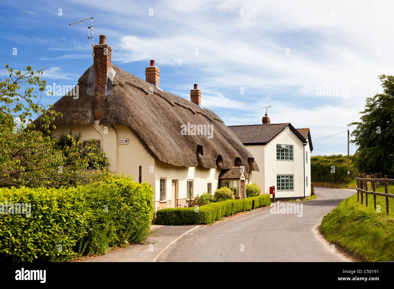 Traditionelle alte losgelöst strohgedeckte Hütten, in den ländlichen englischen Dorf von Tarrant Monkton, Dorset, England, UK im Sommer Stockfoto