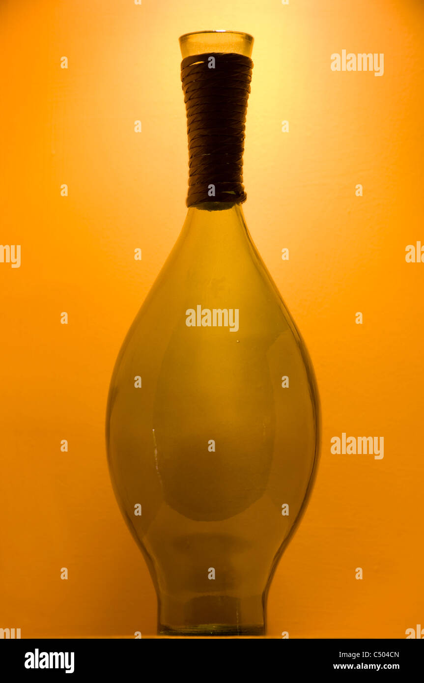 Glas Vase gegen orange Hintergrund unter Spotlight isoliert Stockfoto