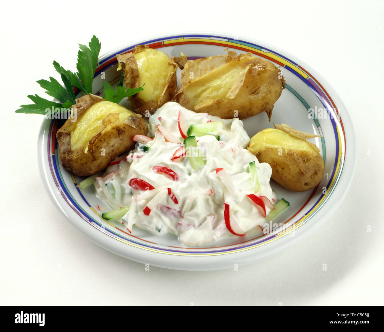Kartoffeln in ihrer Jacke mit Radieschen - Gurken Quark Stockfoto