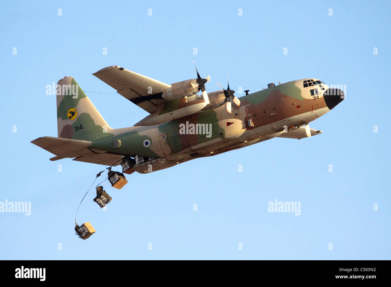 Israeli Air Force c-130 Hercules 100 Flugzeug während des Fluges fällt Ladung an die Truppen am Boden Stockfoto