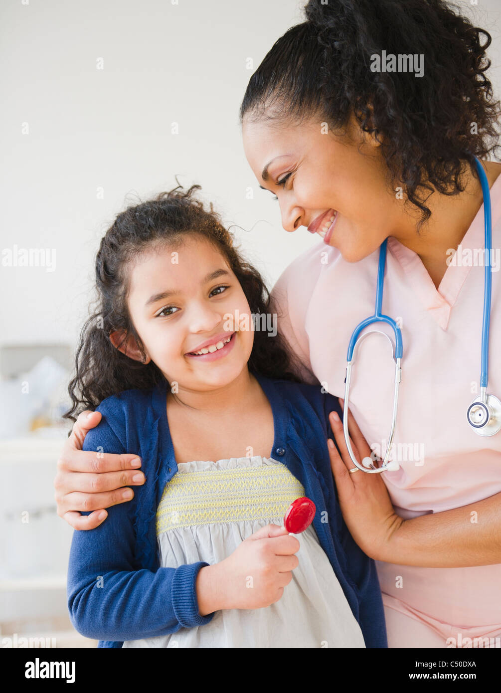 Lächelnde Krankenschwester geben Mädchen Lutscher Stockfoto