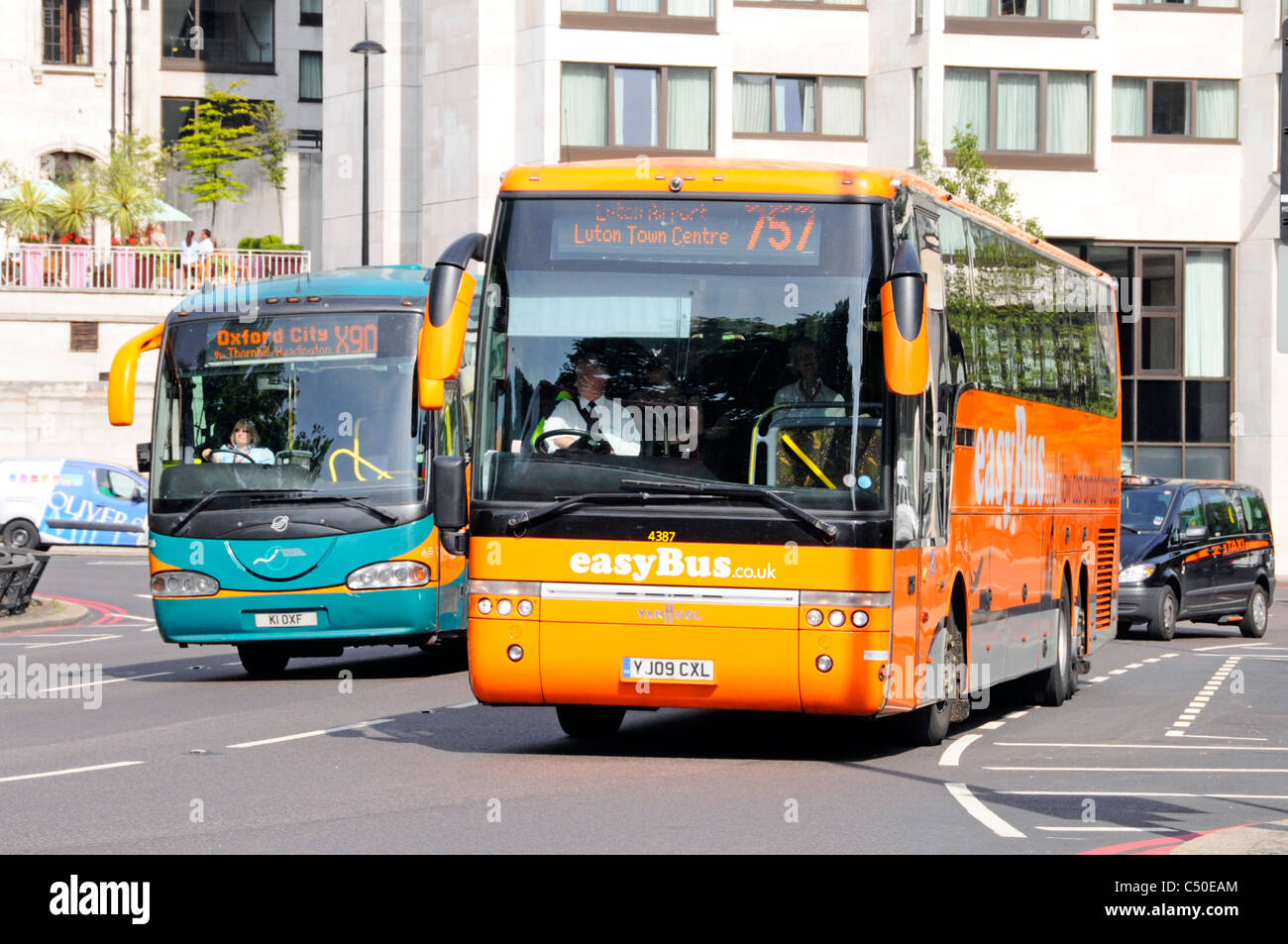 Fahrer von zwei öffentliche Verkehrsmittel Bus Busse auf dem Weg nach Luton und Oxford mit einem Betrieben von EasyBus entlang fahren, Park Lane, London England Großbritannien Stockfoto