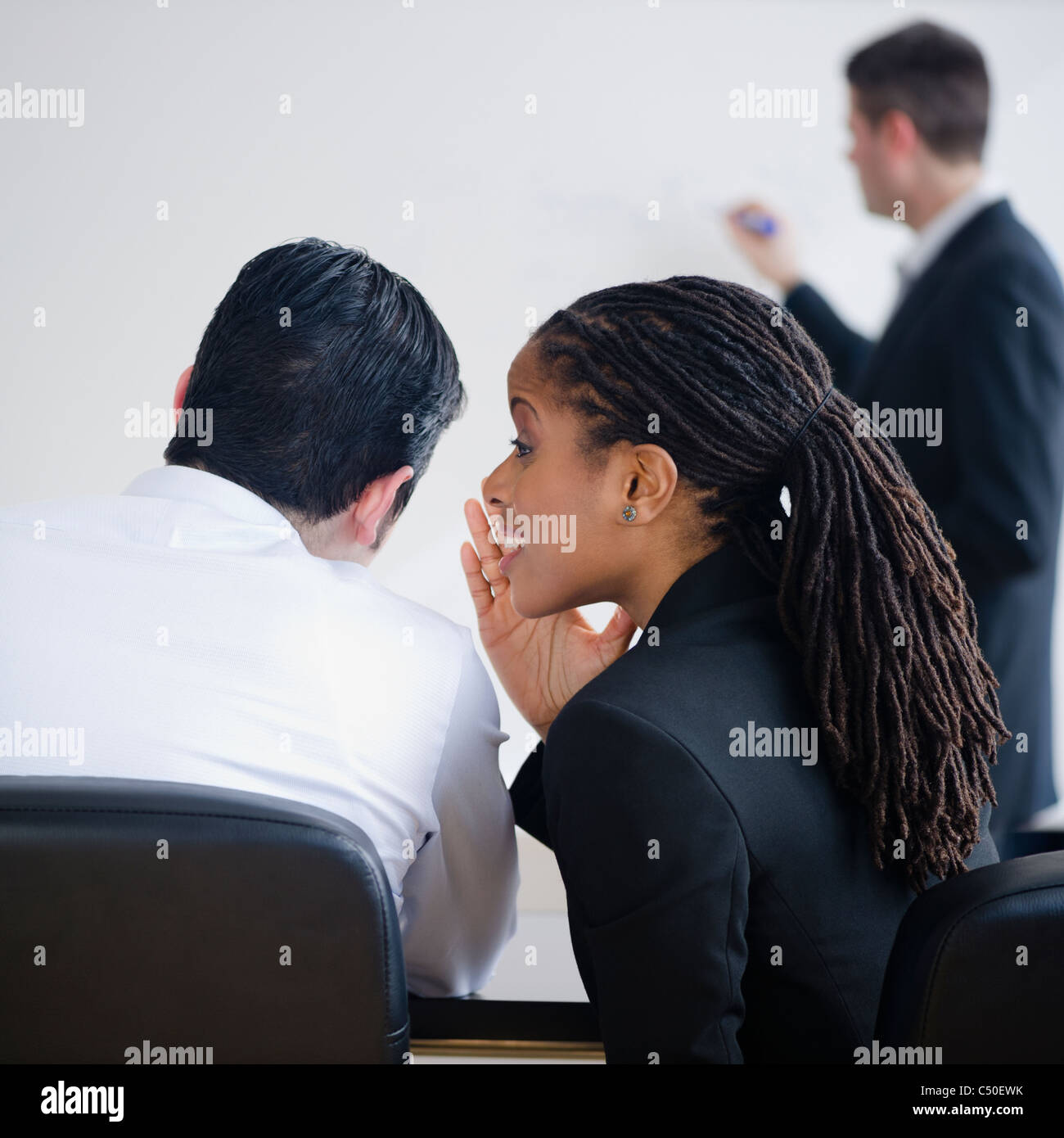 Geschäftsfrau Flüstern an Kollegen treffen Stockfoto