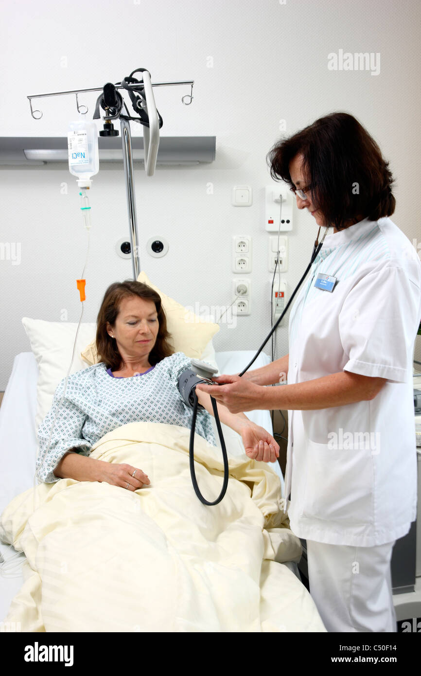 Krankenhaus. Krankenschwester sucht Blutdruck einer Patientin. Stockfoto