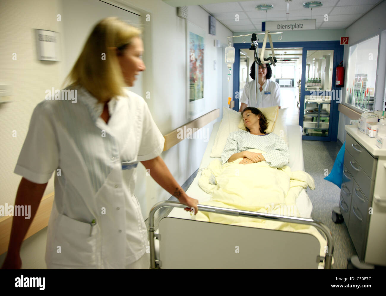 Krankenhaus. Verschieben einer Patientin in ihrem Bett aus ihr  Krankenzimmer zu einem Untersuchungsraum Krankenschwestern Stockfotografie  - Alamy