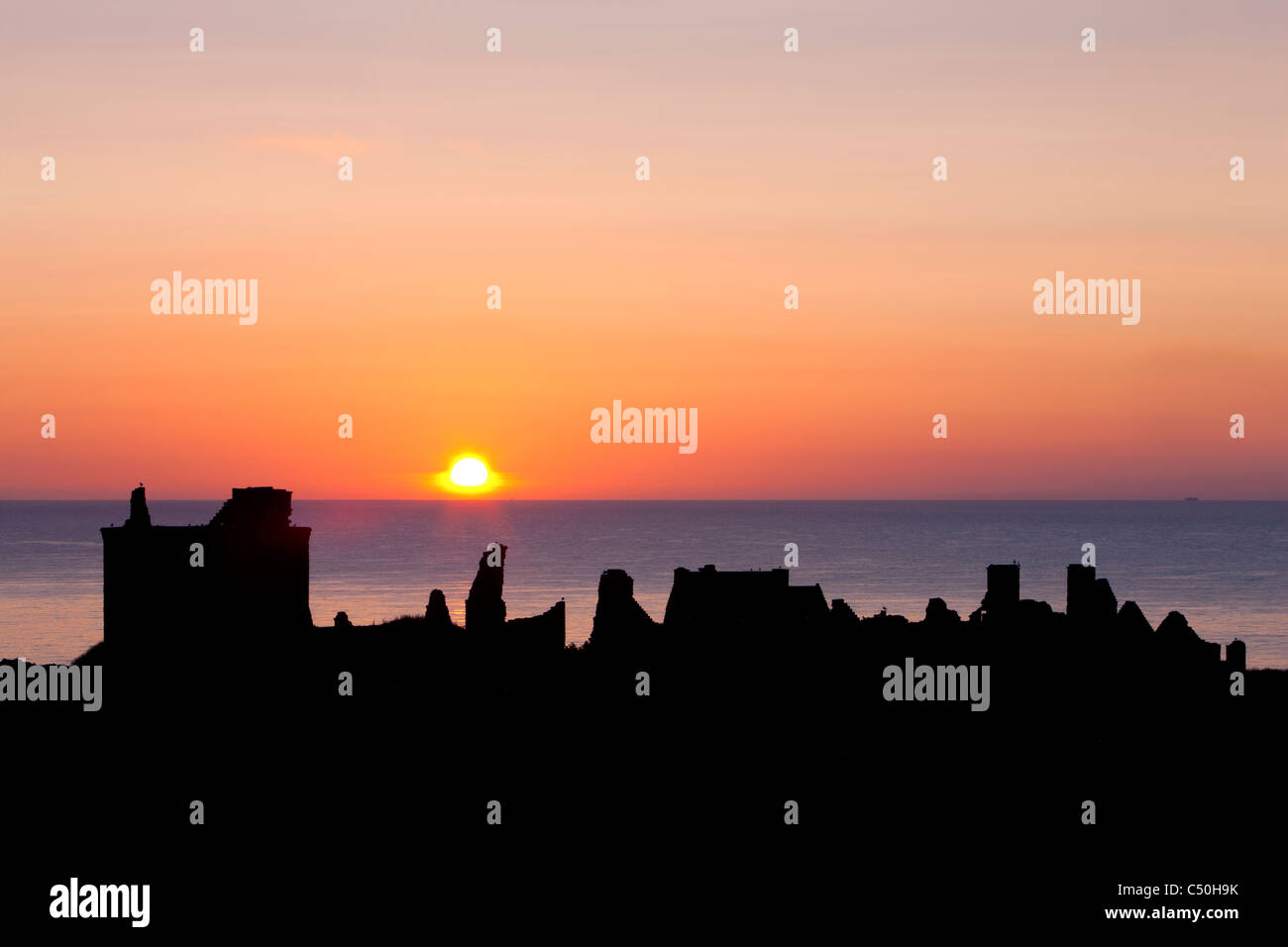 Sonnenaufgang mit den Silhouetten von Dunnottar Castle, in der Nähe von Stonehaven, Aberdeenshire, Schottland Stockfoto