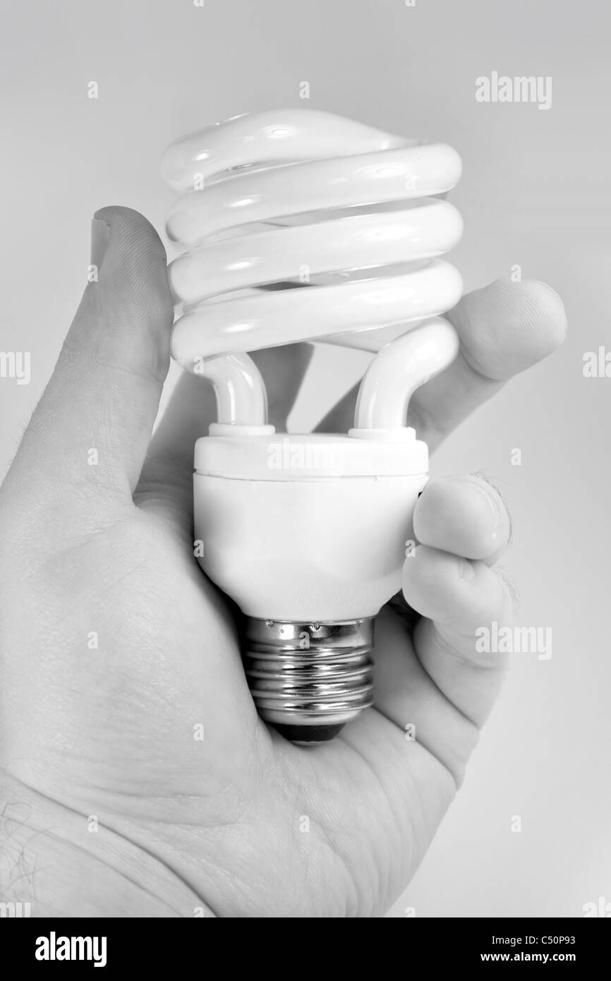 Eine Hand hält eine kompakte Leuchtstoff Glühlampe. Stockfoto