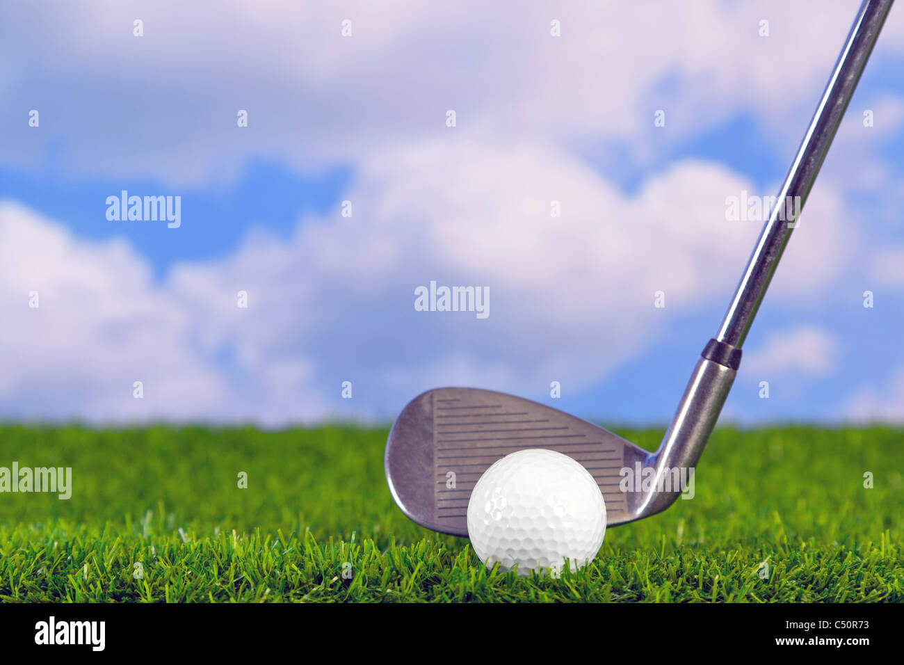 Foto eines Golfclubs Eisen hinter dem Ball auf dem Fairway. Stockfoto