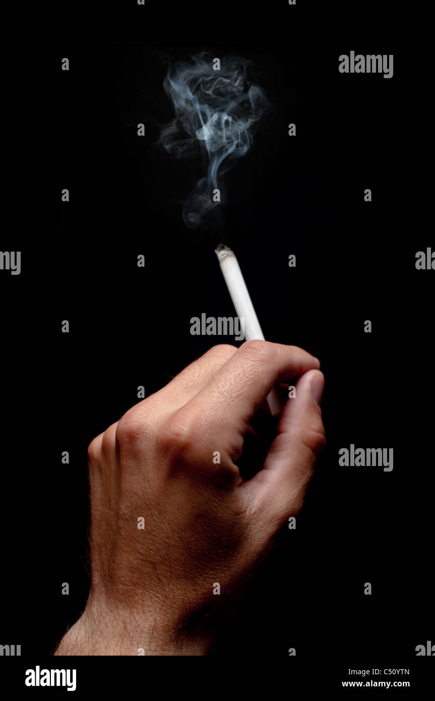 Eine Zigarette rauchen über einem dunklen Hintergrund, niedrige Schlüssellicht. Stockfoto