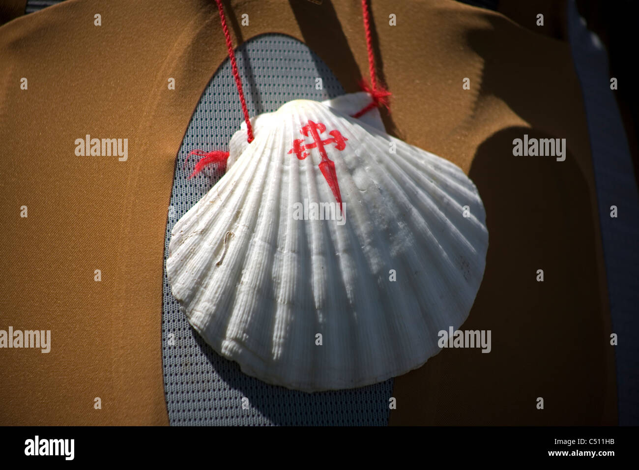 Eine Jakobsmuschel mit dem Kreuz des Heiligen Jakobus hängt in einem Rucksack ein Pilger zu Fuß in die französische Lebensart St. James Weg, Spanien Stockfoto