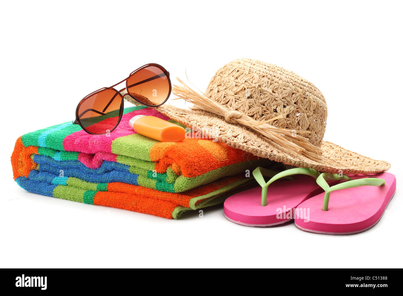 Strandzubehör mit Strohhut, Handtuch, Flip Flops und Sonnenbrillen. Isoliert auf weißem Hintergrund. Stockfoto