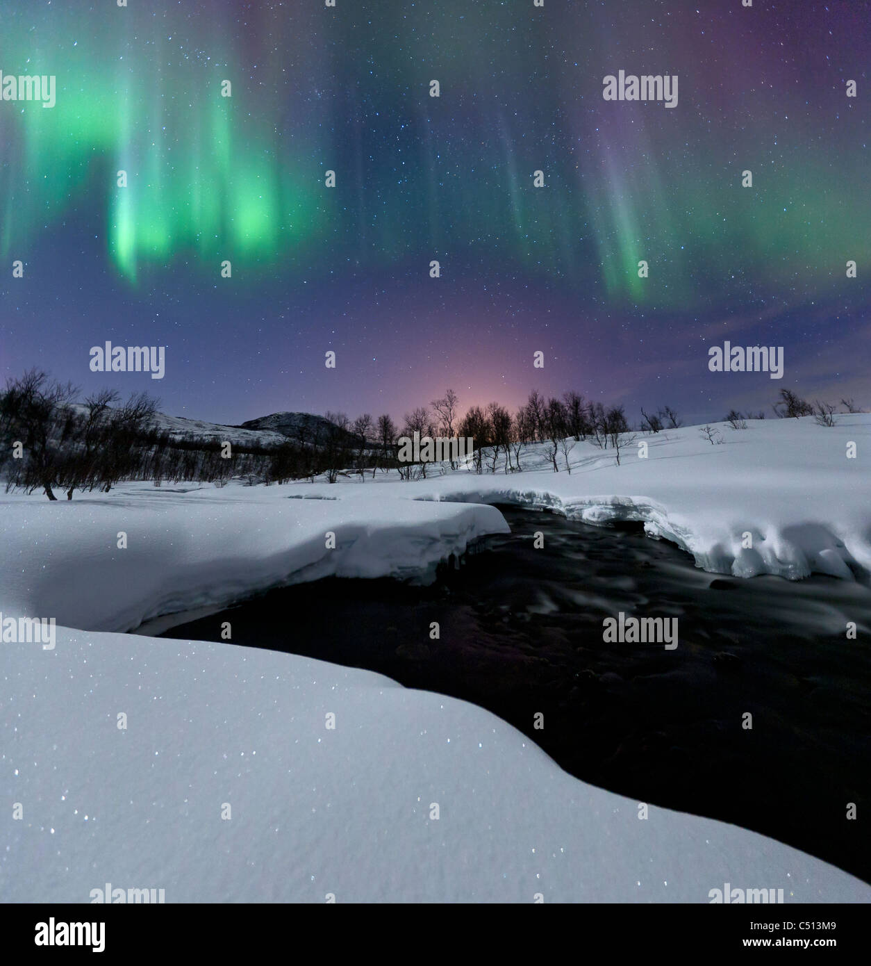 Aurora Borealis über Blafjellelva Fluss in Troms Grafschaft Stockfoto