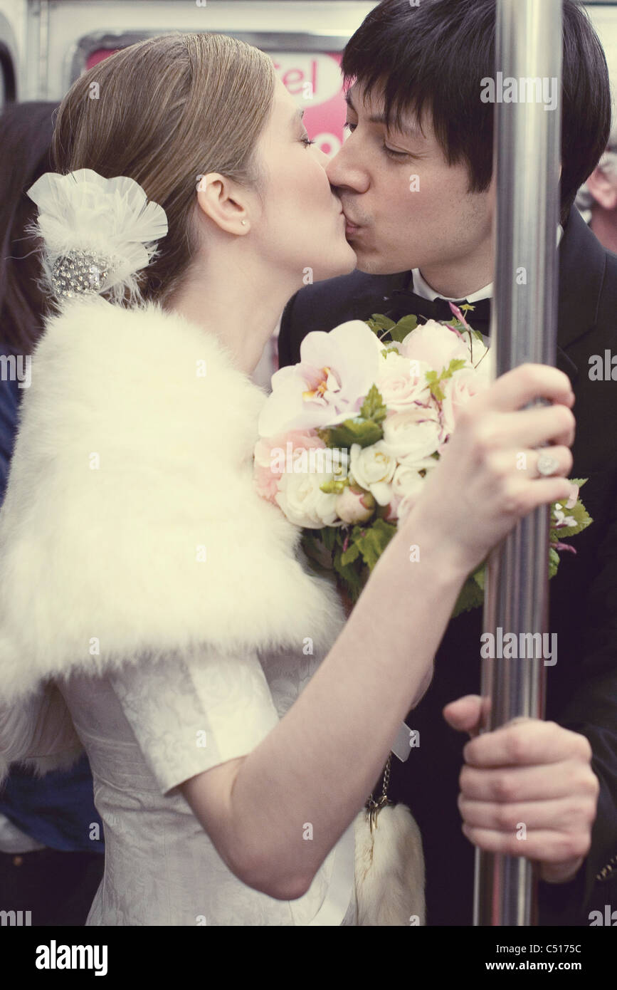 Braut und Bräutigam küssen auf u-Bahn Zug Stockfoto