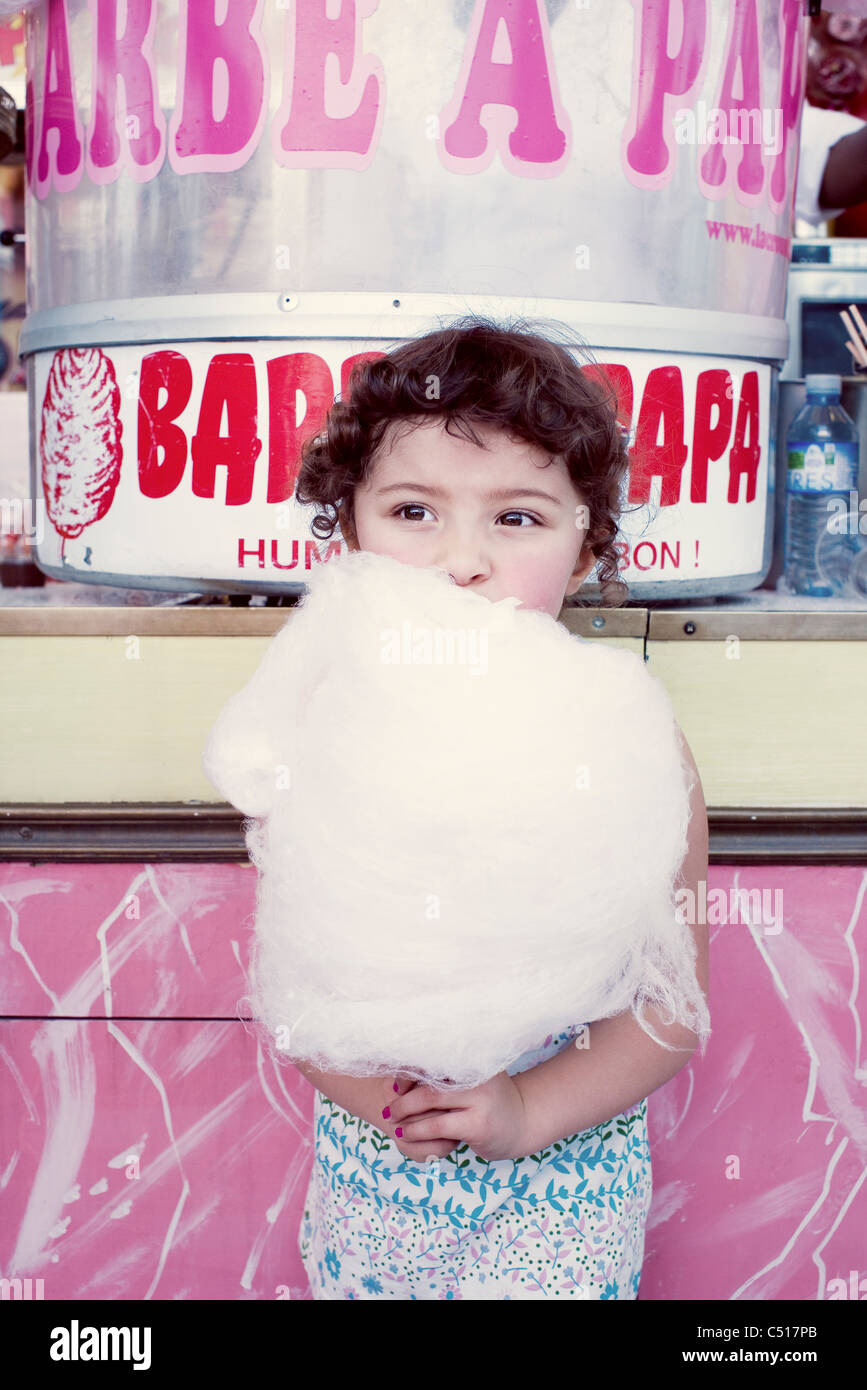 Kleine Mädchen essen Zuckerwatte auf Messe Stockfoto