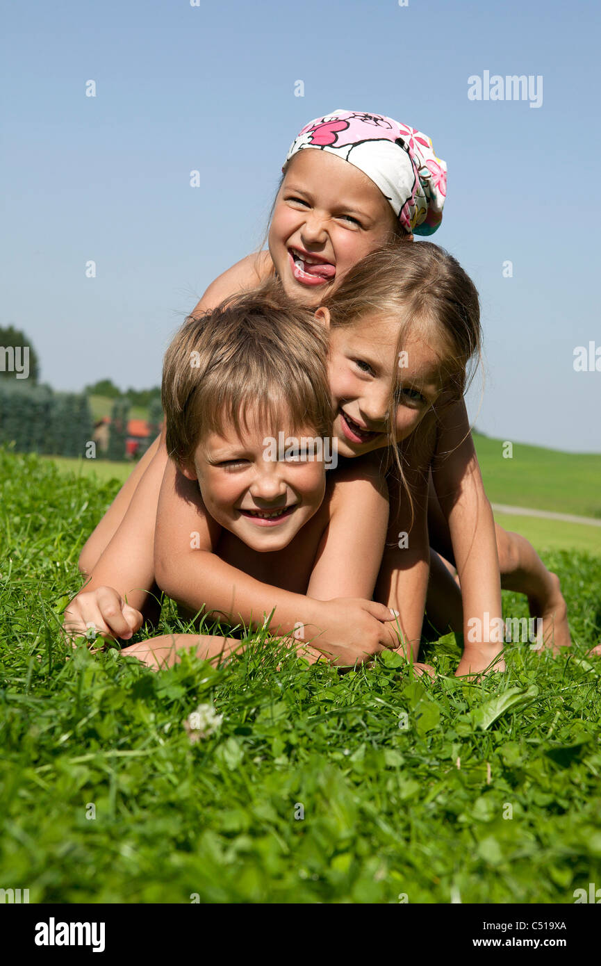 Porträt von drei Kindern im Grass liegen Stockfoto