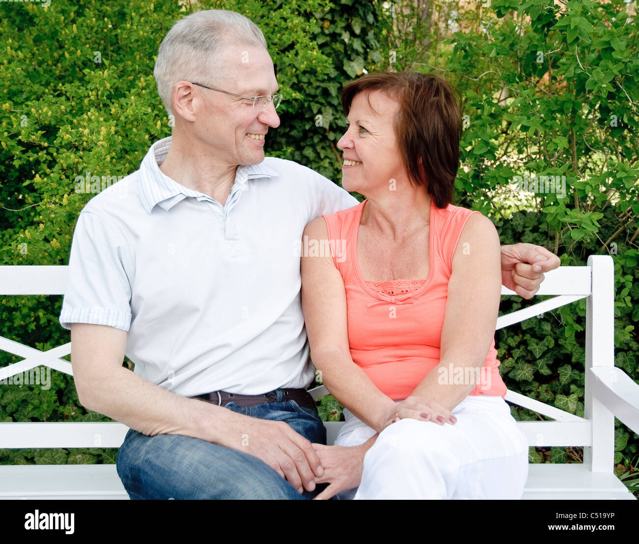 Paar mittleren Alters sitzen auf einer Bank Stockfoto