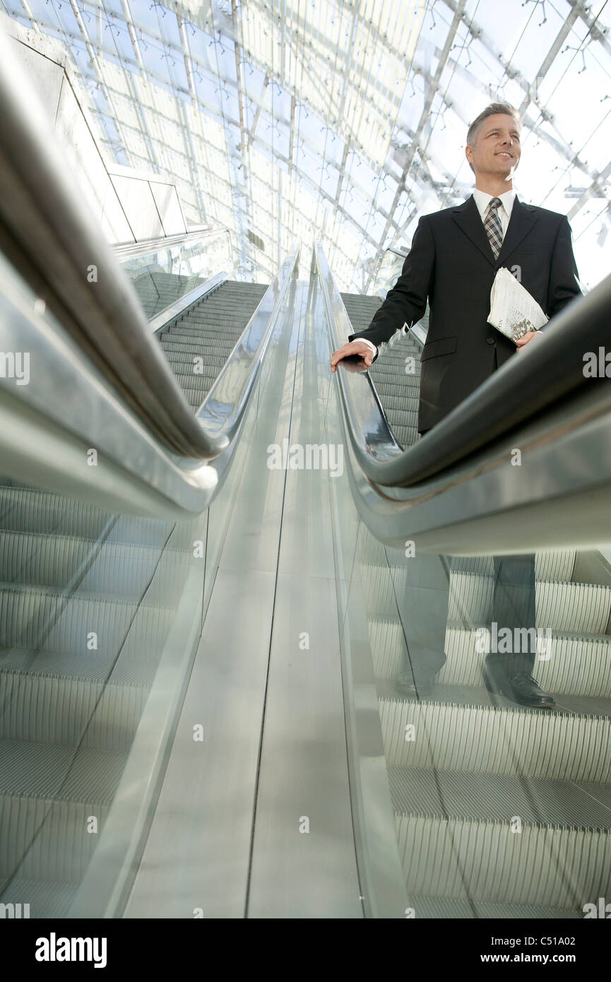 Geschäftsmann, stehen auf der Rolltreppe Stockfoto