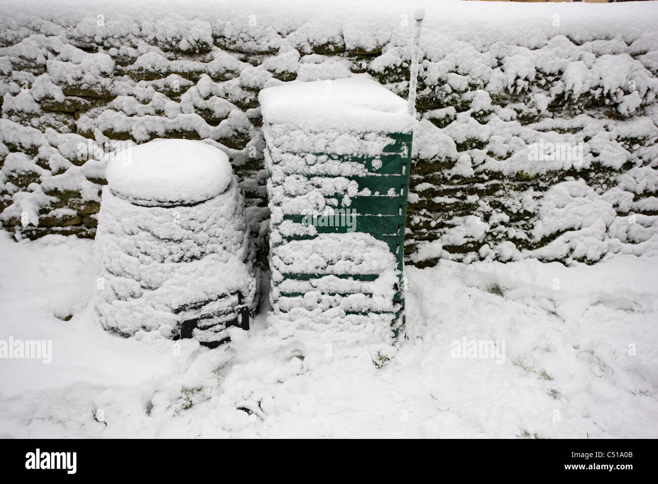 Zwei Arten von Kunststoff Garten Komposter kompostieren mit Schnee bedeckt Stockfoto