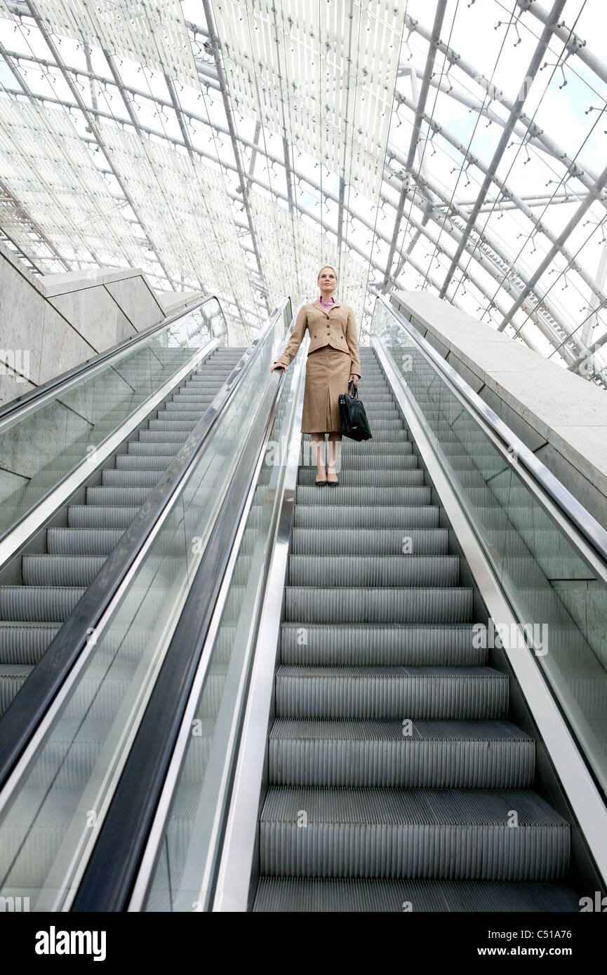 Geschäftsfrau auf Rolltreppe Stockfoto