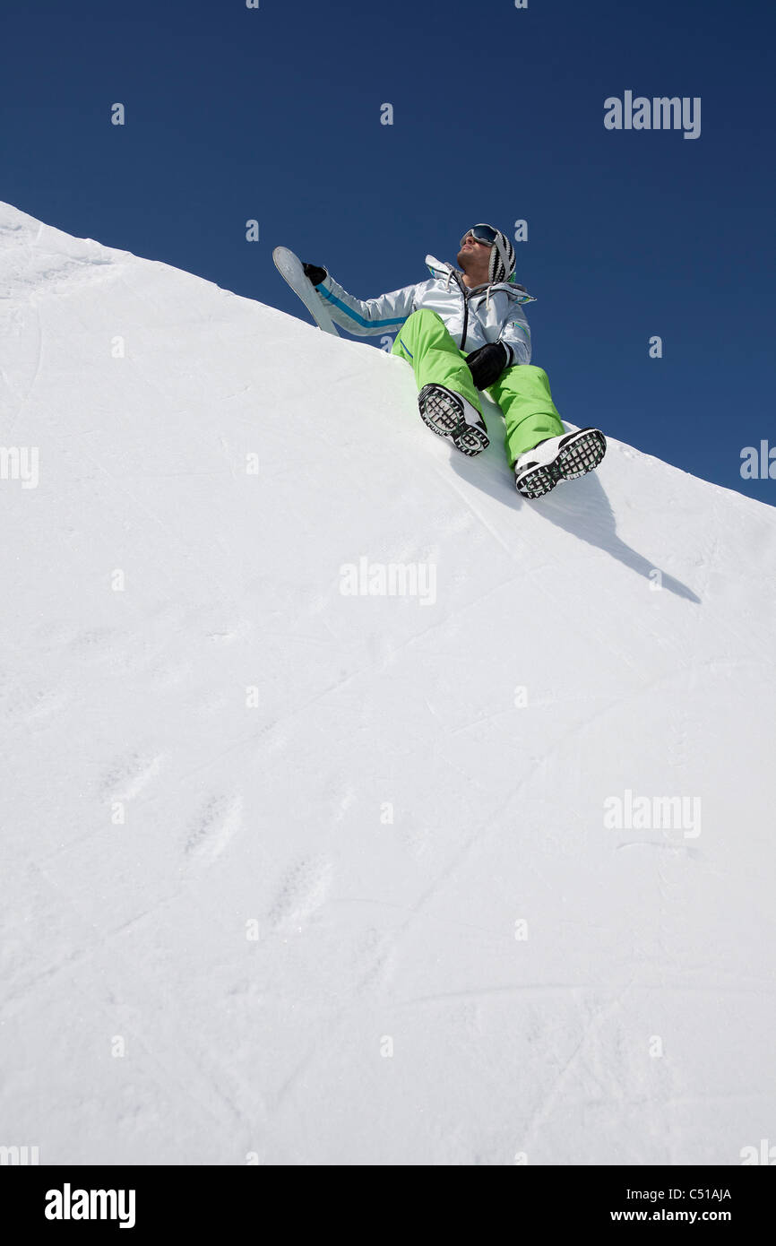 männlichen Skifahrer sitzen auf Schnee Stockfoto