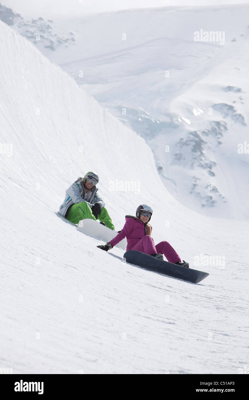 junges Paar Snowboarden in den Bergen Stockfoto