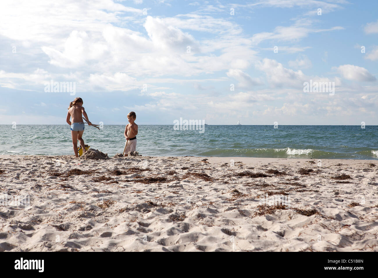 Schwester und Bruder spielt im Sand am Strand Stockfoto