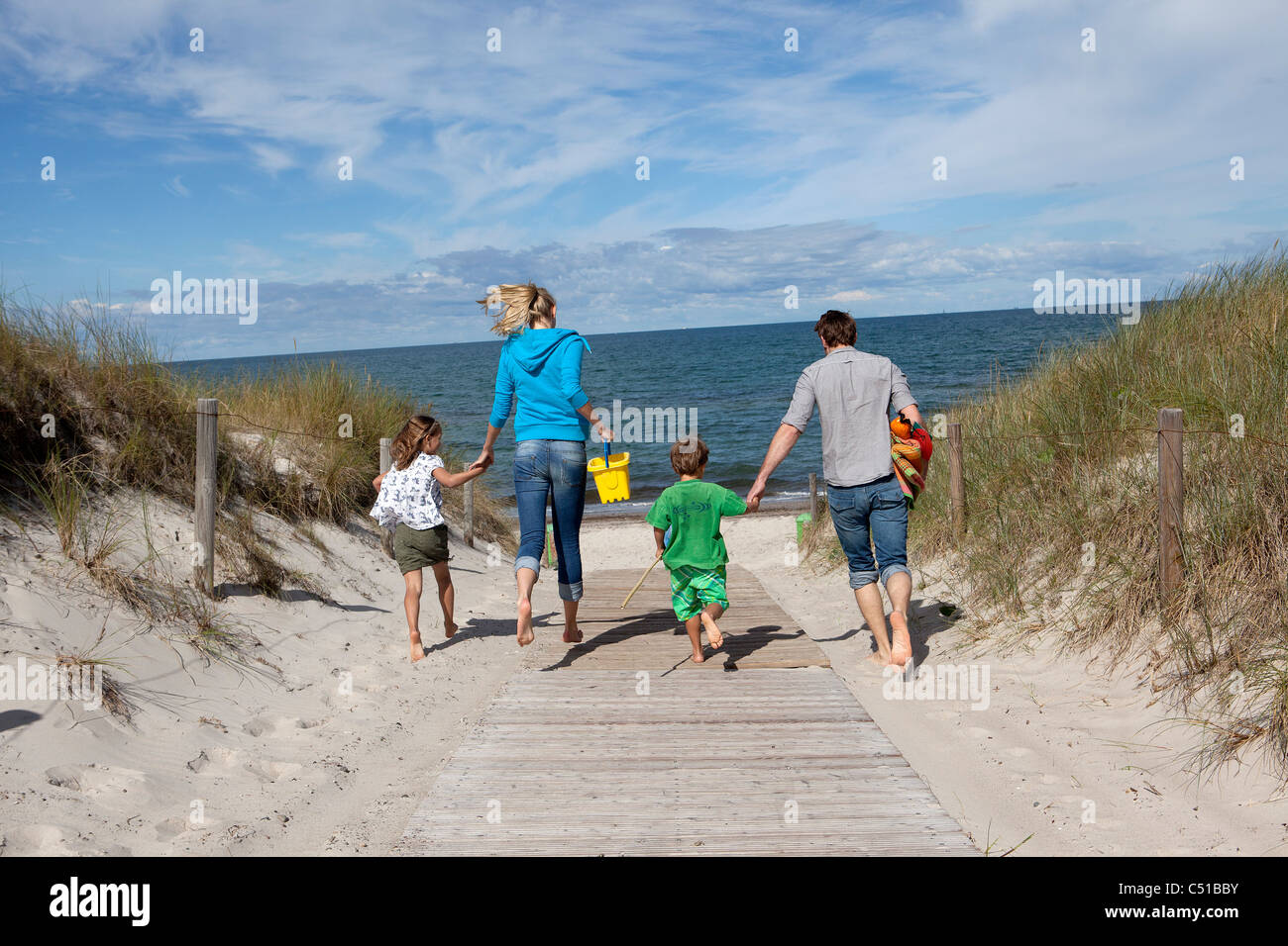 Familie läuft in Richtung Strand Stockfoto