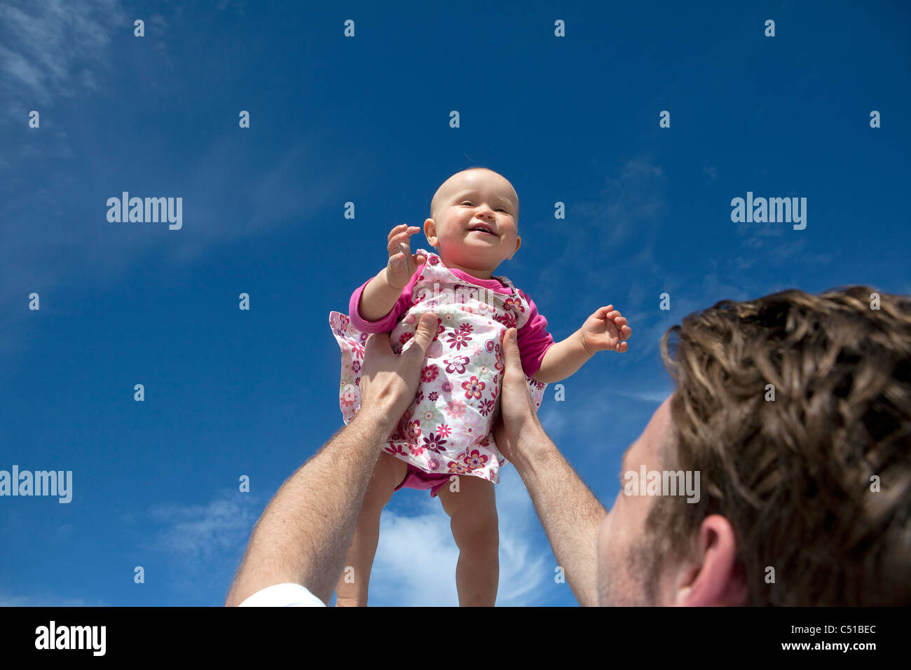 junger Vater Holding Baby oben in der Luft Stockfoto