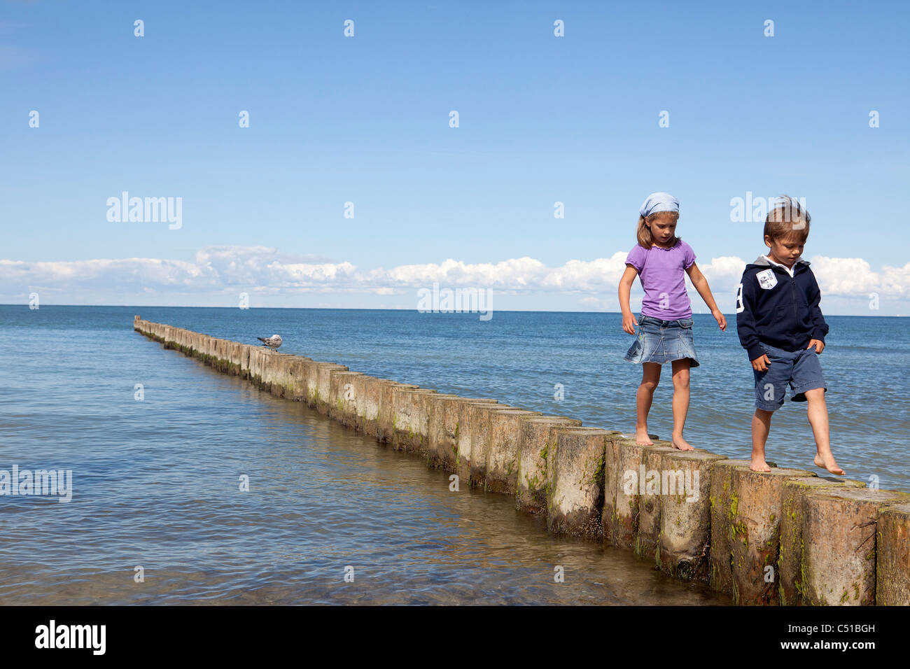 Schwester und Bruder gehen auf Polen am Meer Stockfoto