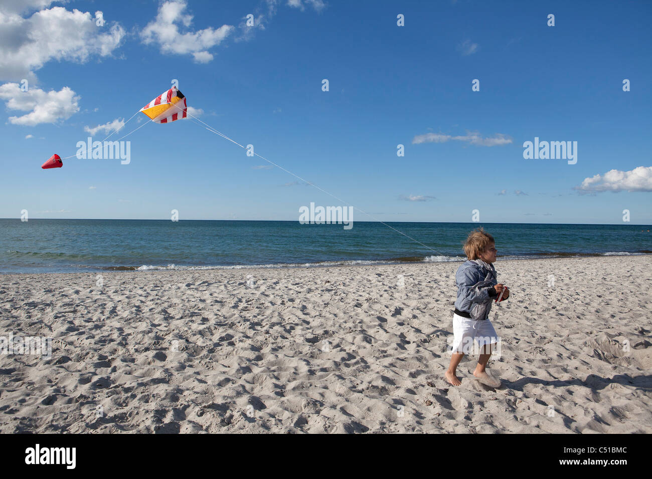 kleiner Junge spielt mit Kite am Strand Stockfoto