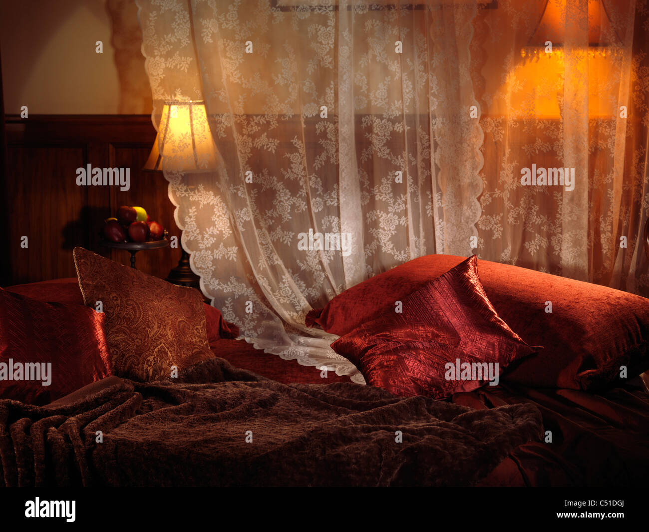 Schwach beleuchteten Schlafzimmer mit dunklen roten Bett und zwei Lampen. Innere Einstellungen. Stockfoto