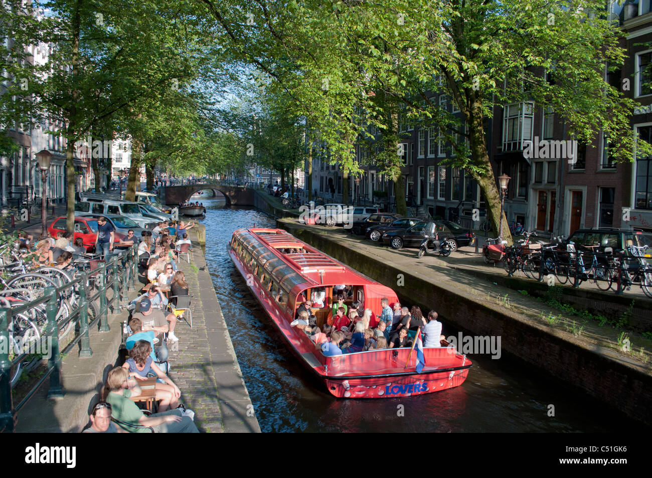 Ein Schiff segelt auf einen malerischen Kanal in der niederländischen Stadt Amsterdam. Stockfoto