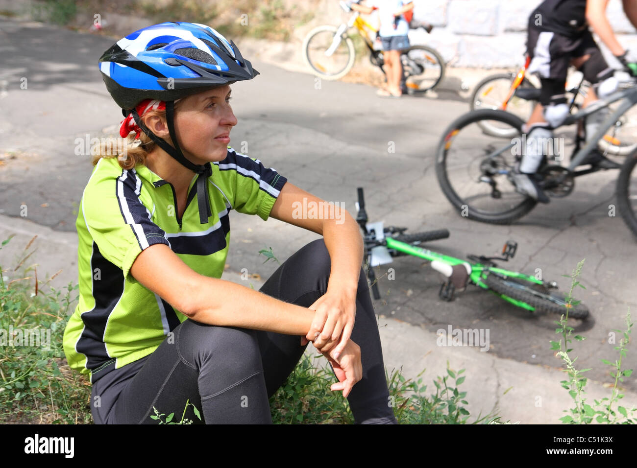 Sportliche Wettkämpfe. Eine Frau Radfahrer sitzen auf Rasen Stockfoto
