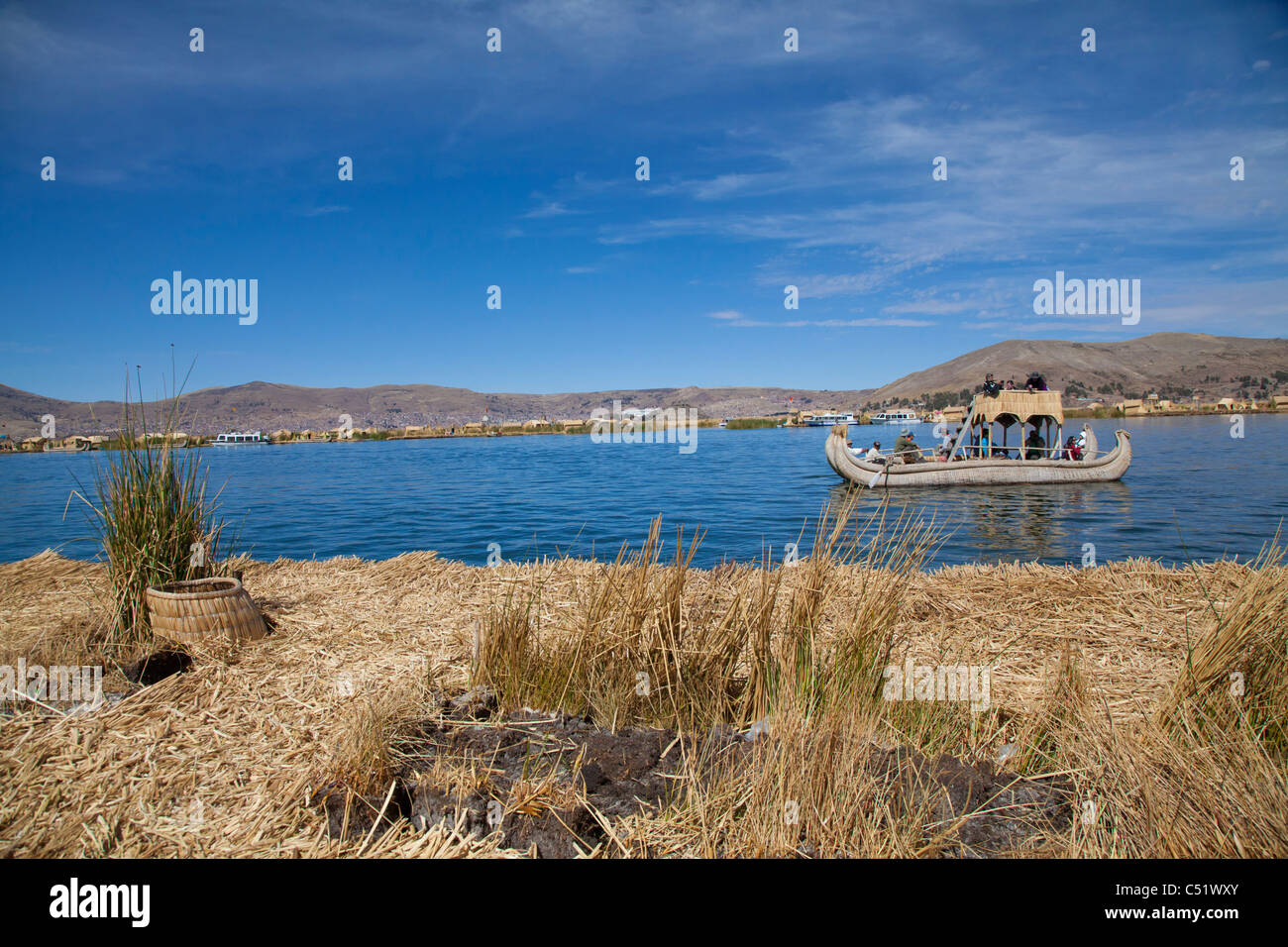 Blick aus einem der schwimmenden Inseln der Uros Touristen gerudert wird in einem traditionellen Reed Boot, Titicacasee, Peru Stockfoto