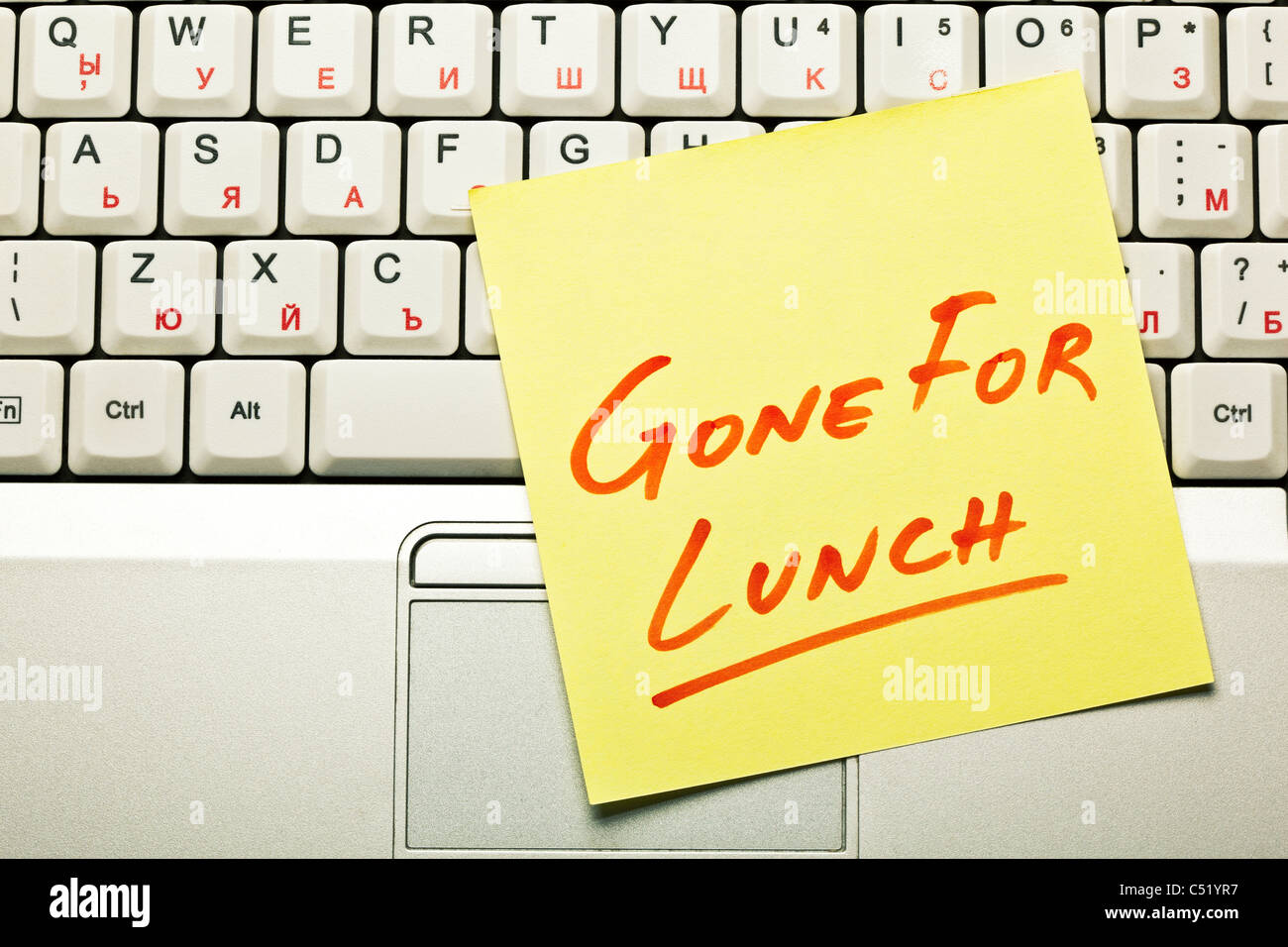 Gelbe Haftnotiz auf einer Laptoptastatur mit 'Gone für das Mittagessen"drauf. Stockfoto