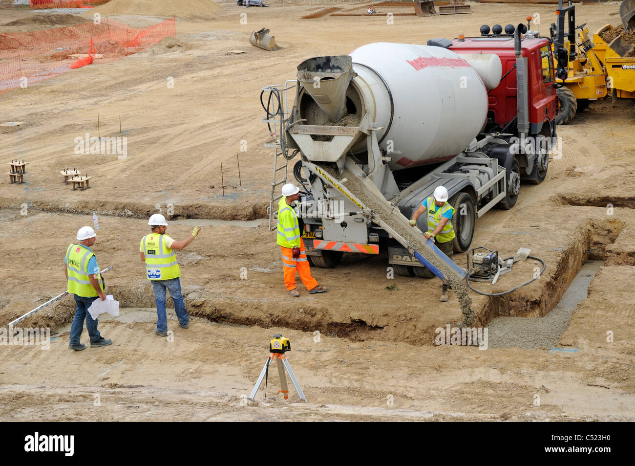 Baustelle zeigt Streifen Stiftung Gräben und Betonmischer liefern konkrete. Stockfoto