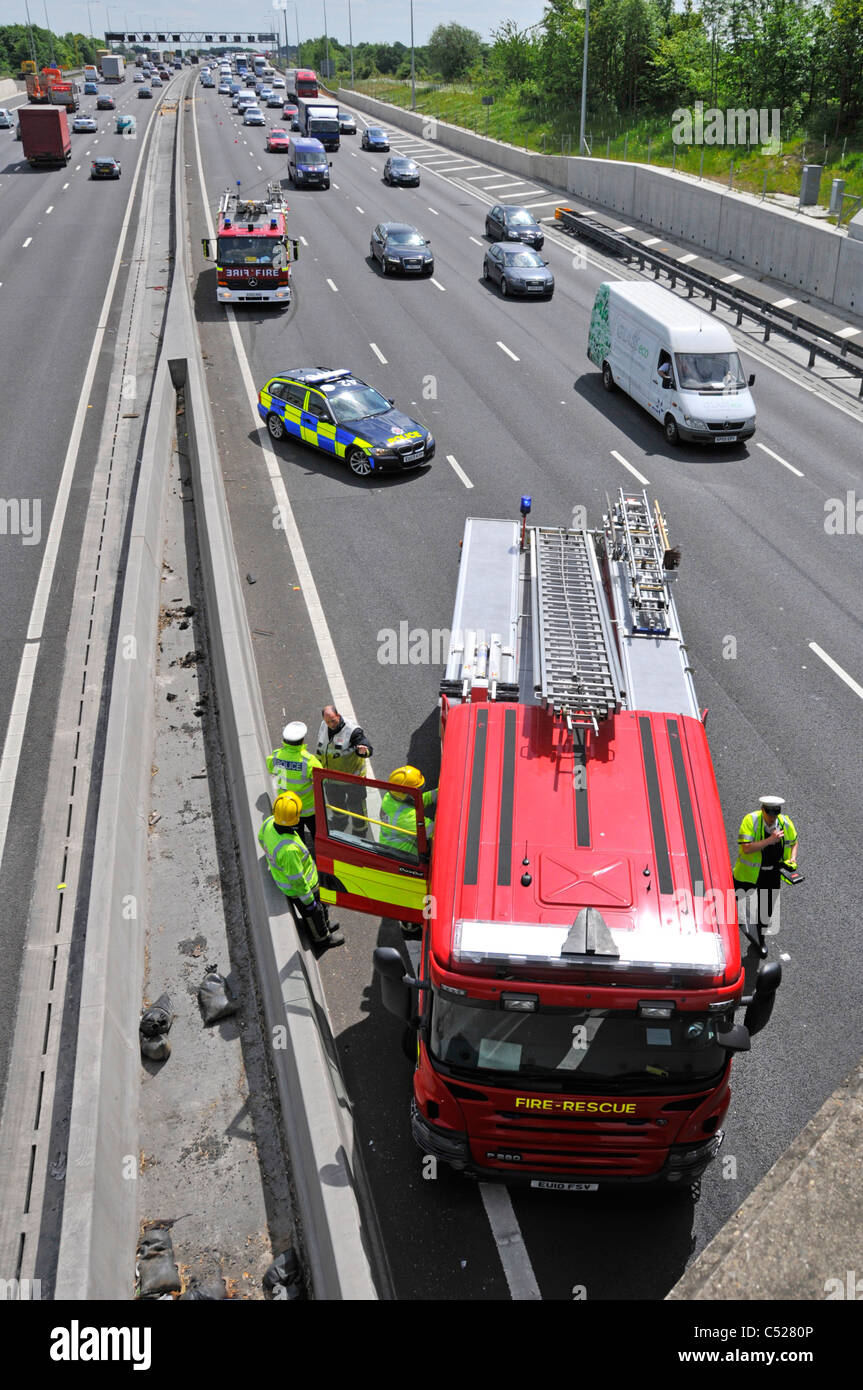 Polizeiauto und Ankunft am Unfallort (unter Brücke) Parken in Lane vier Feuerwehrautos Stockfoto