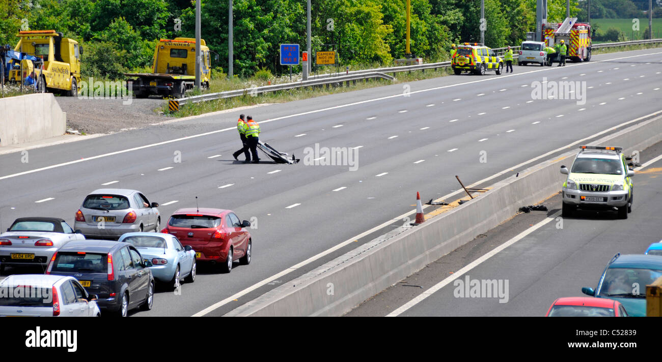 Autobahn Notdienste Teilnahme an zwei Unfälle auf gegenüberliegenden Fahrbahnen, klar Highways Agency Verkehr Offiziere Schutt Stockfoto