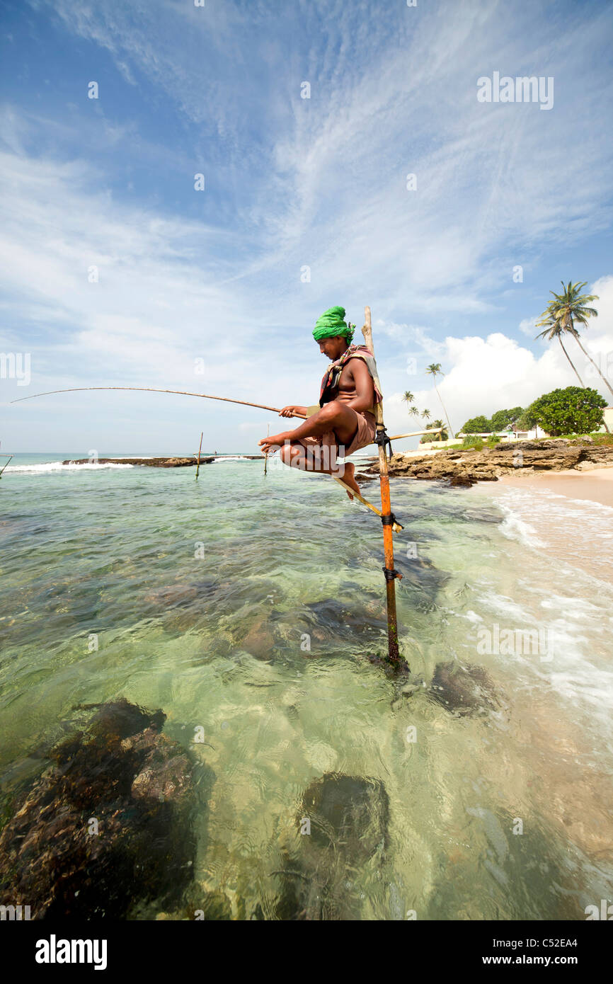 traditionelle Stelzenfischer bei Arbeiten am Strand in der Nähe von Koggala, LKA, Sri Lanka Stockfoto