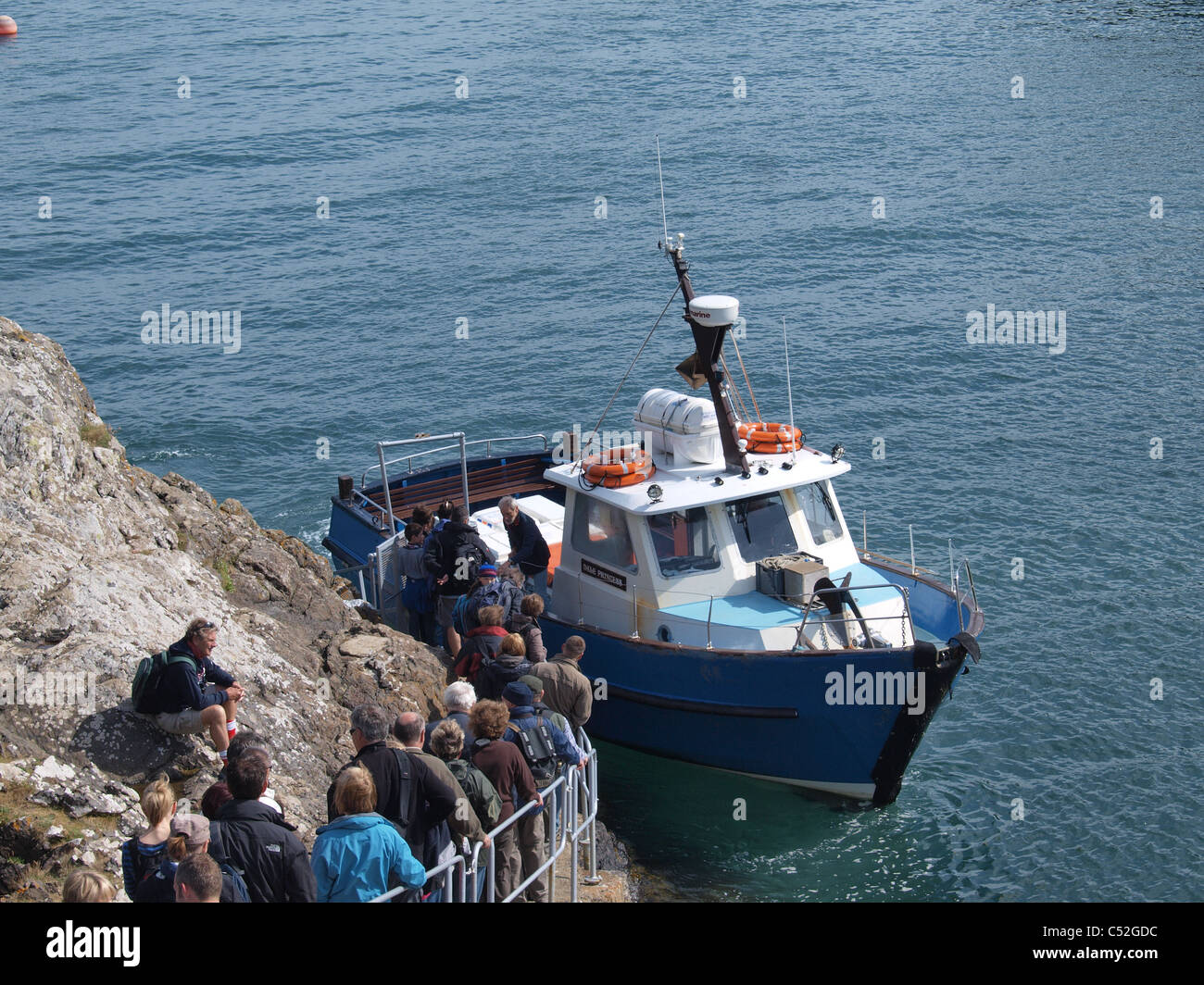 Ornithologen wartet an Bord Boot Skomer Island verlassen. Pembrokeshire. UK Stockfoto