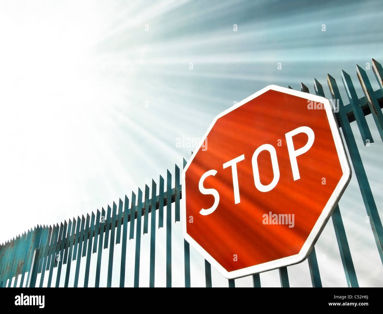 Stop-Schild auf dem Tor in Sonnenstrahlen Stockfoto