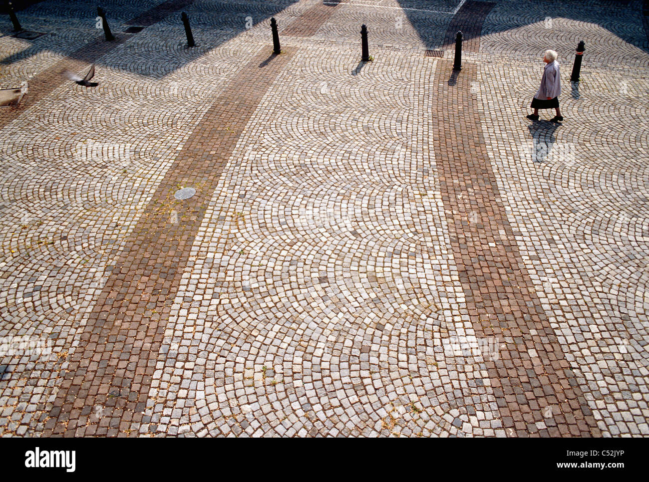 Frau geht durch Pflastersteine in Deutschland. Stockfoto
