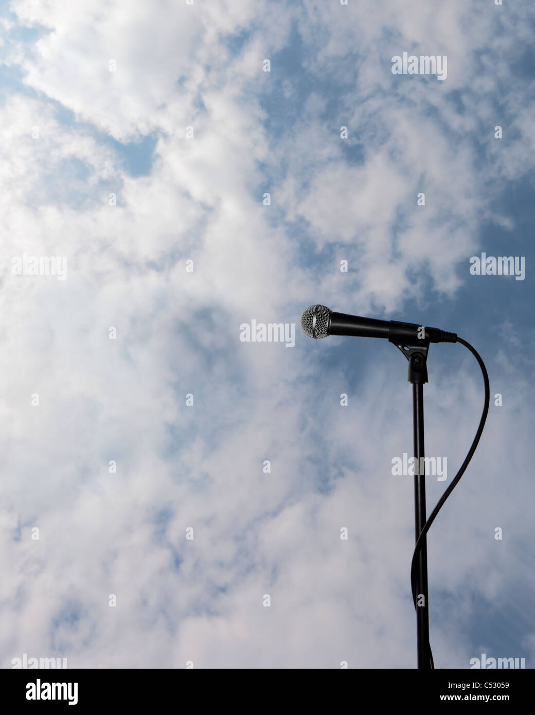 Mikrofon und Stand gegen einen bewölkten blauen Sommerhimmel. Stockfoto