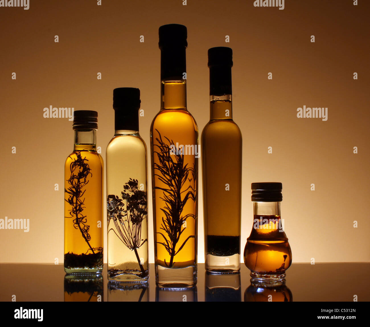 Sammlung von Flaschen Olivenöl von hinten beleuchtet und unter den Flaschen Stockfoto