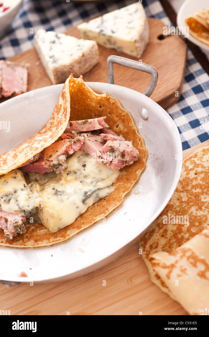 Französisches Essen: Crepe gefüllt mit Blauschimmelkäse und Schweinefleisch gewürzt Stockfoto