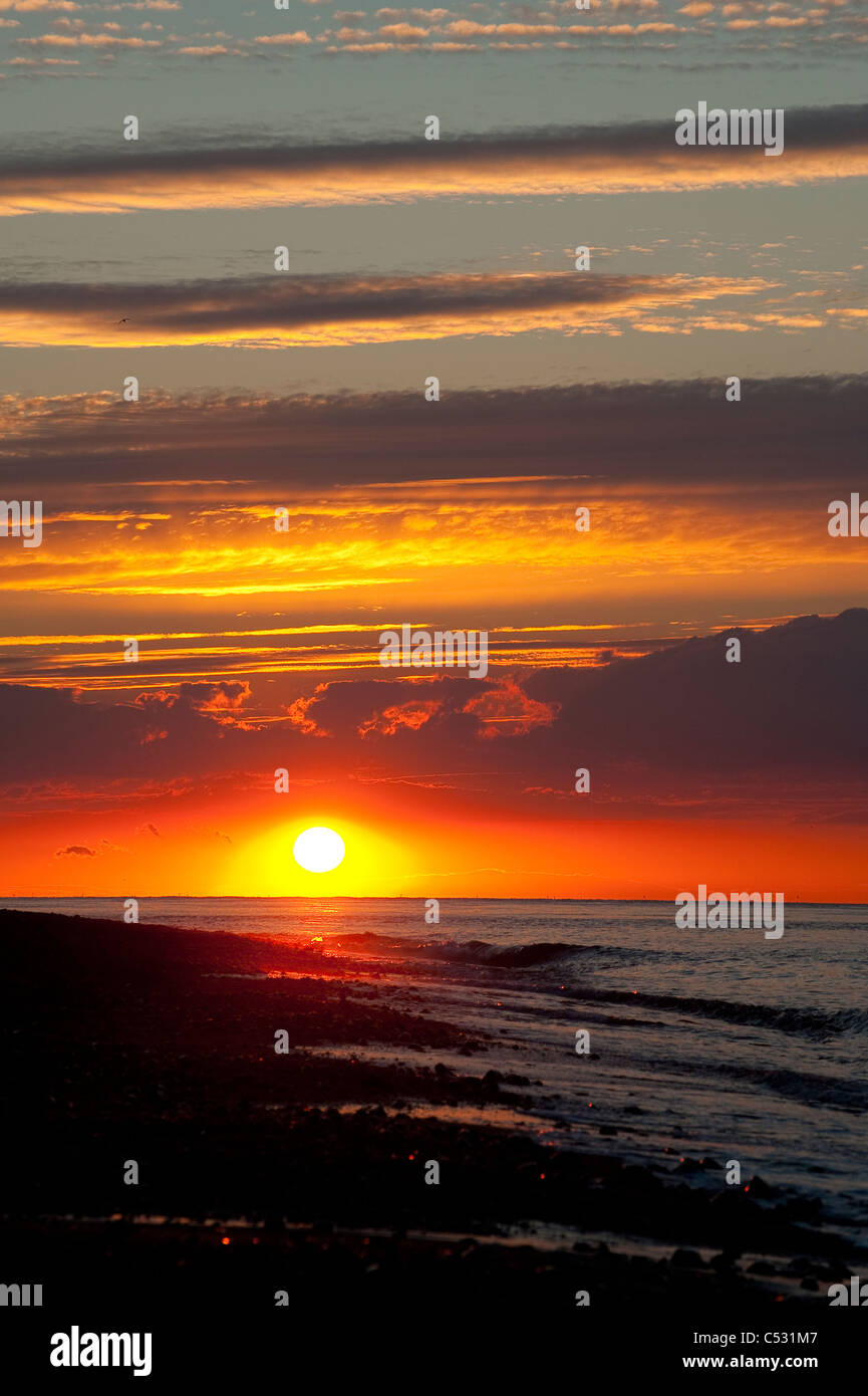 Atemberaubende roten Himmel bei Sonnenuntergang an der Küste, East Anglia, England. Stockfoto