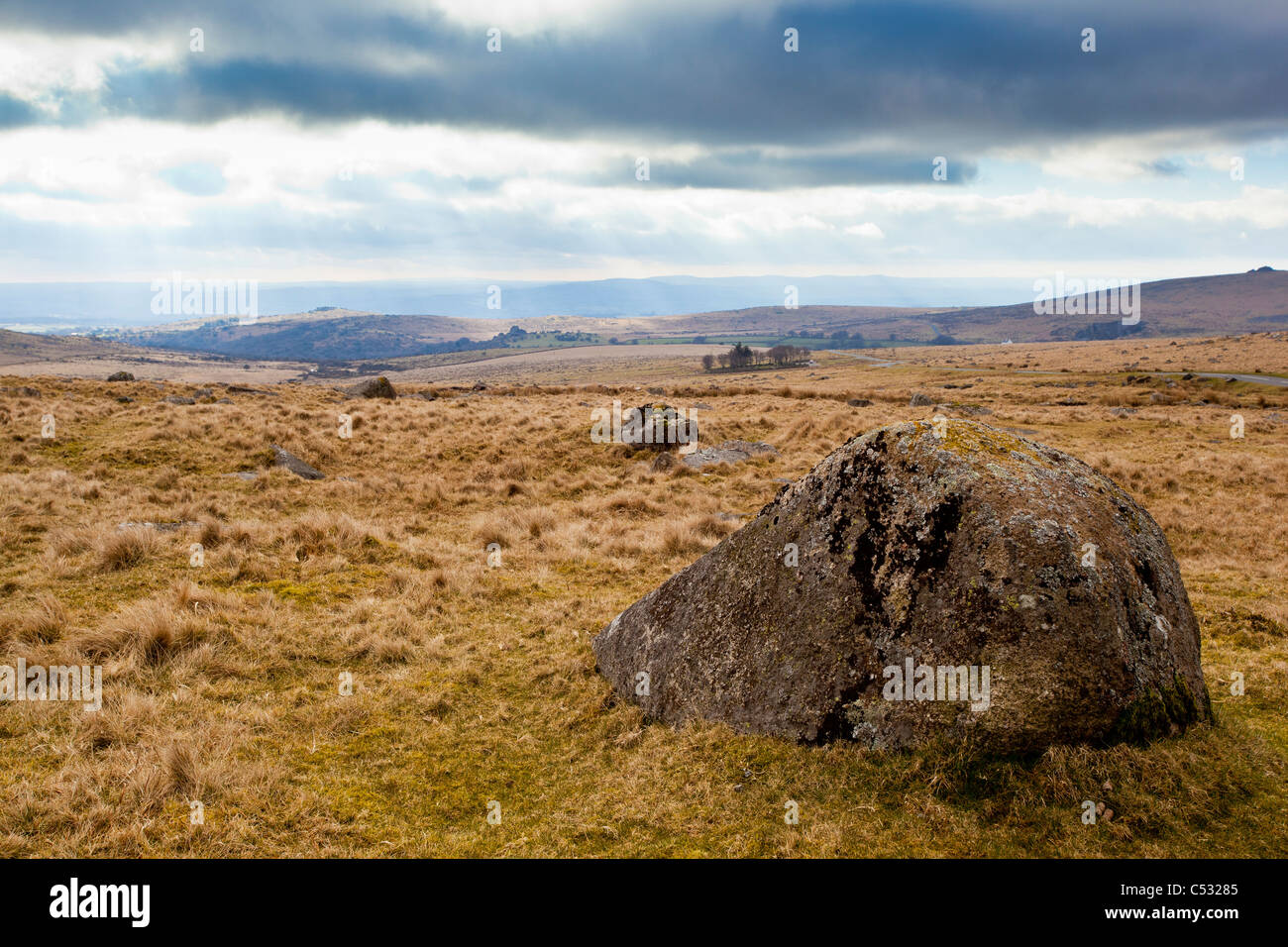 Boulder in Dartmoor National Park, England, mit Sonnenstrahlen im Hintergrund Stockfoto