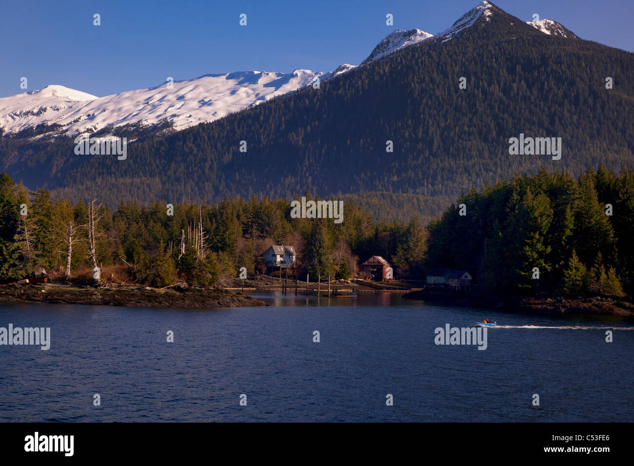 Malerische Aussicht der Häuser entlang der Küste in der Nähe von Ketchikan mit Bergen im Hintergrund, Inside Passage, Südost-Alaska Stockfoto