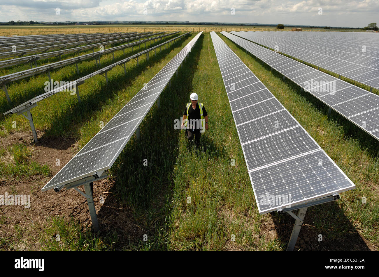 UKs erste solar Kraftwerk im Bau Fen in der Nähe von Louth Lincolnshire und Ecotricity Wind Farm hinter Stockfoto